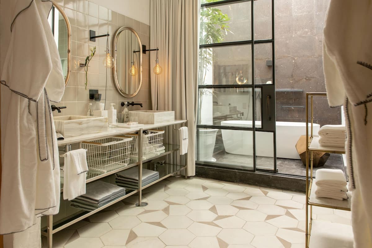 Un baño moderno con dos lavamanos, un espejo grande y una ventana con vistas al exterior.
