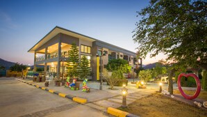 A modern hotel with a two-story structure, outdoor seating area, and a heart-shaped decoration.