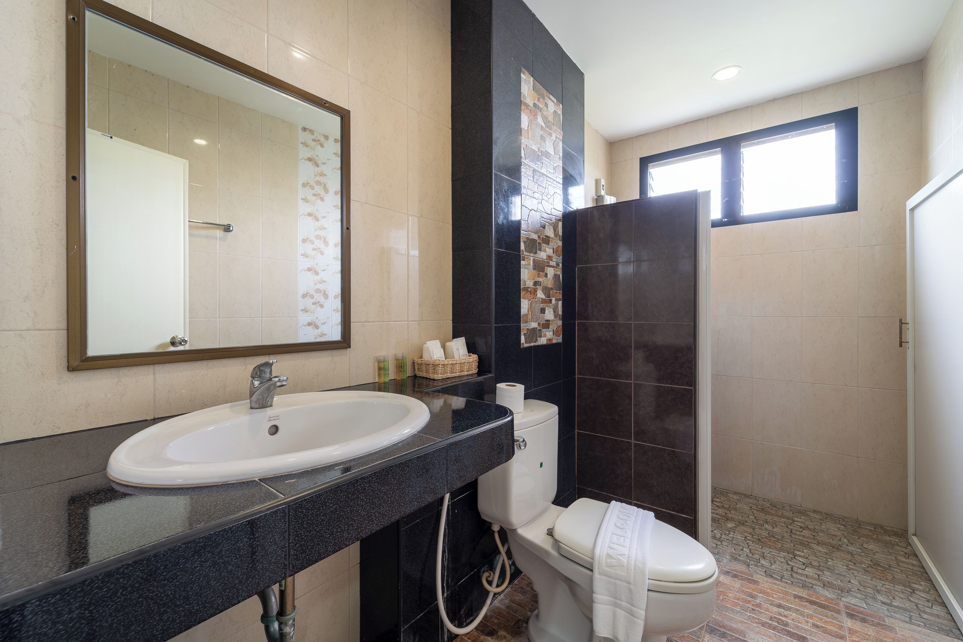 A bathroom with a white sink, a toilet, and a shower area.