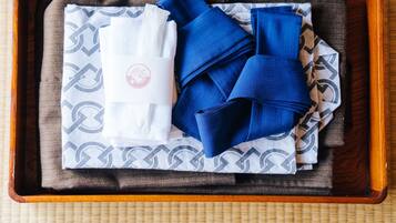 A wooden tray with folded towels and a patterned cloth.