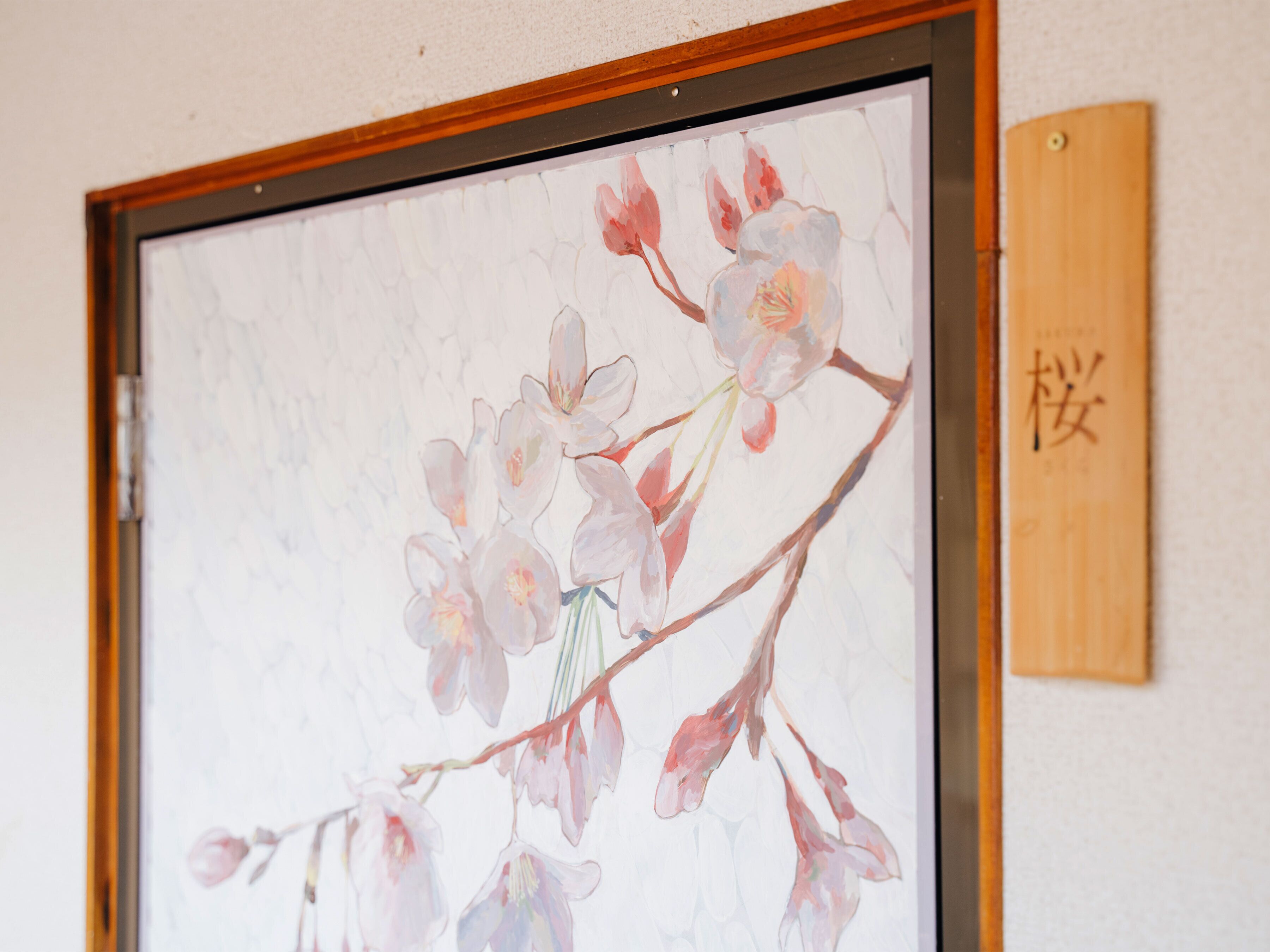 A framed artwork of flowers on a wall.