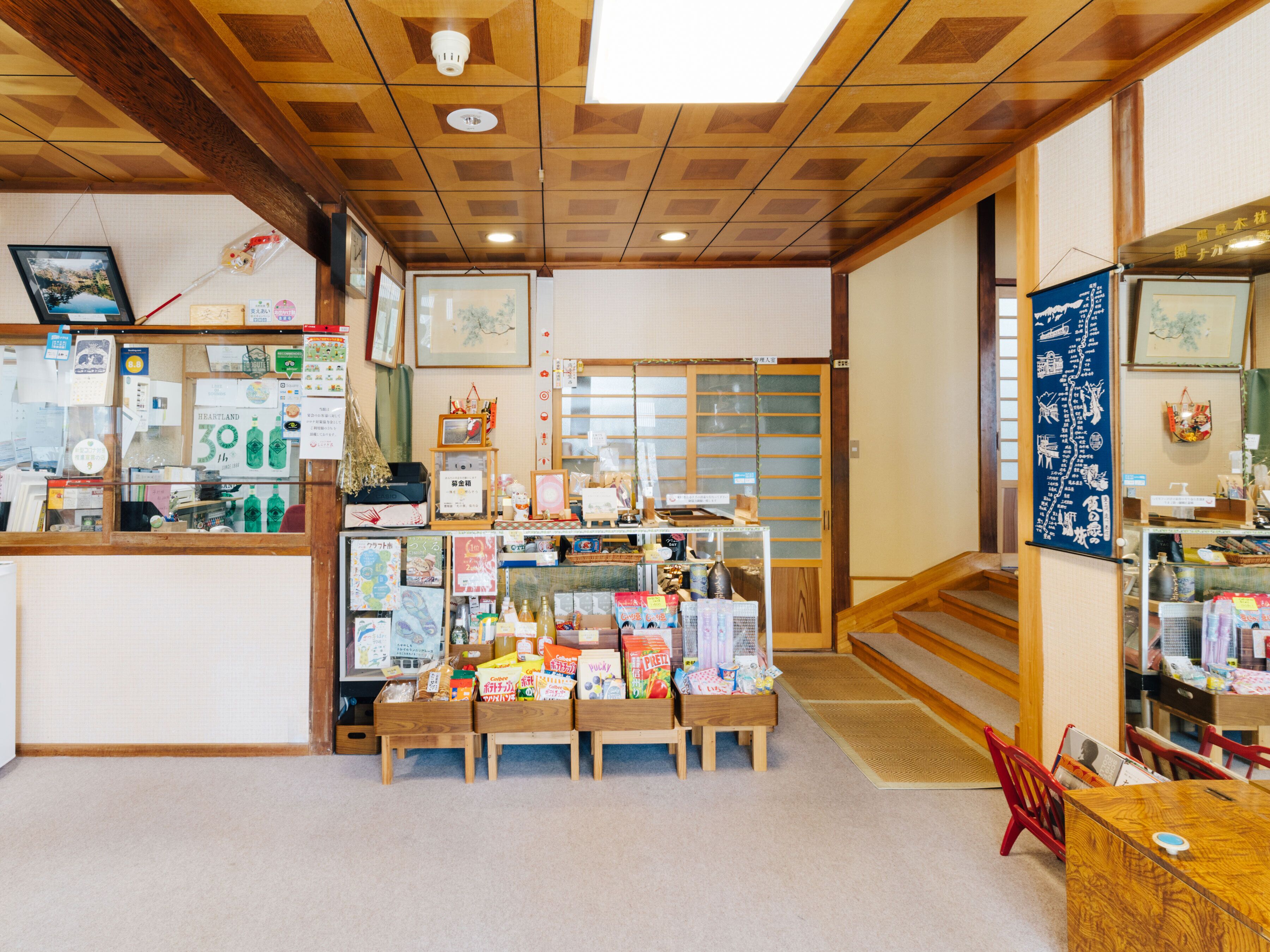 A traditional Japanese store interior with wooden furniture, a display counter, and various items for sale.