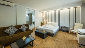 A modern hotel room with a bed, a sofa, a coffee table, and a chair. - Panlaan Boutique Resort (Nong Khai)