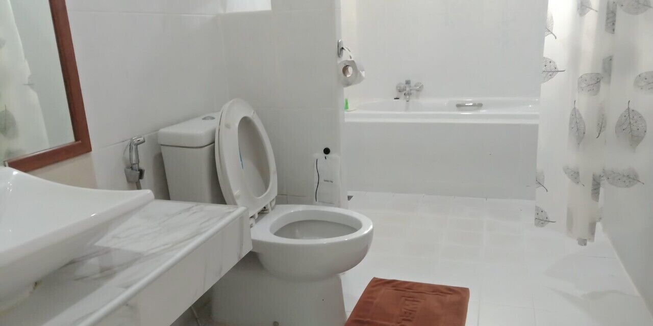 A bathroom with a toilet, sink, and bathtub.