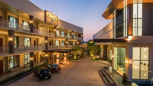A multi-story hotel with a central courtyard, balconies, and a pool area. - Panlaan Boutique Resort (Nong Khai)