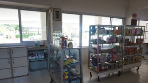 A store with glass display cases containing various products. There are shelves with items and a counter with a cash register.