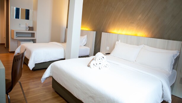 Habitación de hotel con dos camas, techo de madera y diseño moderno.