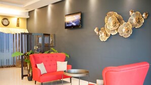 Una sala de estar moderna con un sofá rojo, una mesa de centro redonda y un televisor montado en la pared.