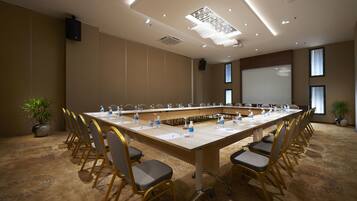 A conference room with a long table, chairs, and water bottles.