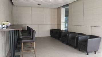 A modern waiting area with a long bench, several chairs, and a small table with flowers.
