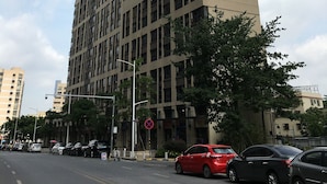 Um edifício alto e moderno com fachada plana e várias janelas.