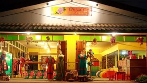 A storefront with mannequins displaying dresses and a sign that reads "Chezmol Handicraft & Home Stay". - Chezmoi Handicraft & HomeStay (Chiang Rai)