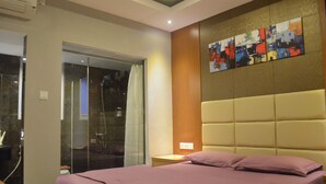 Une chambre à coucher comprenant un lit, une table de chevet, une œuvre d’art accrochée au mur et un espace douche.