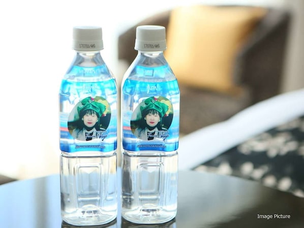 Deux bouteilles d’eau, dont les étiquettes comportent une photo et du texte, sont posées sur une table.