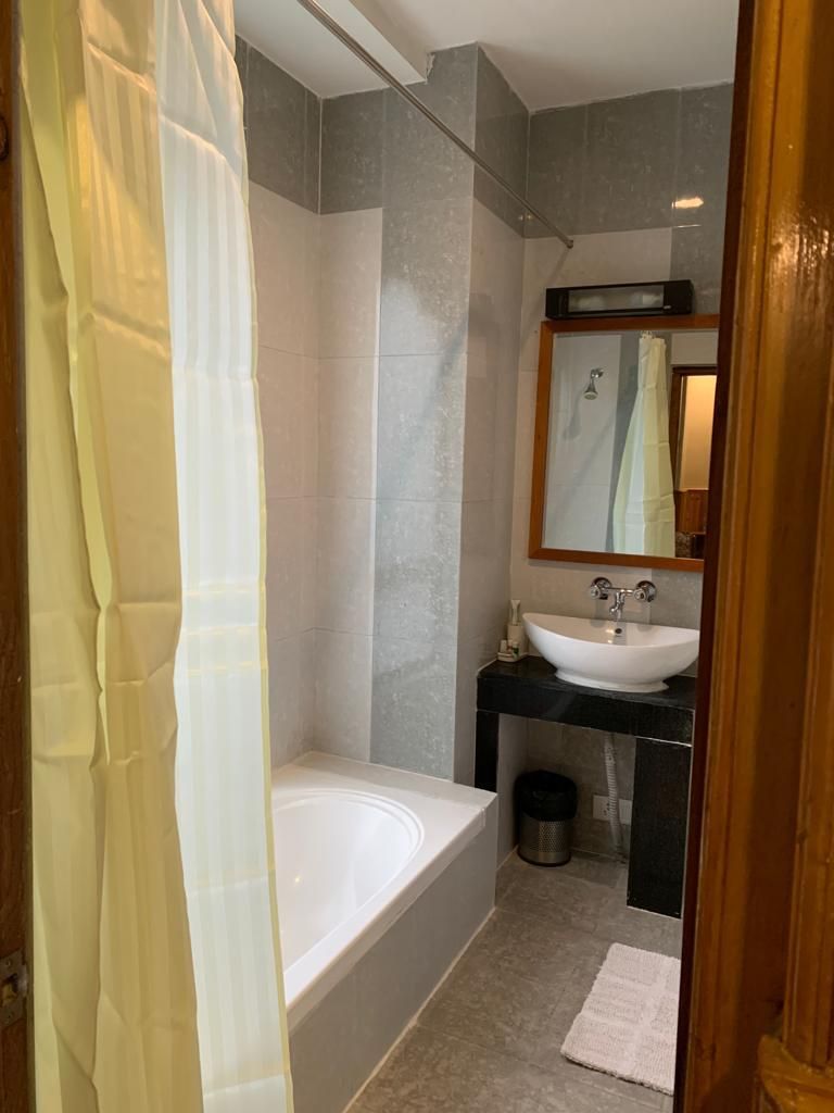 A modern bathroom with a bathtub, a sink, and a mirror.