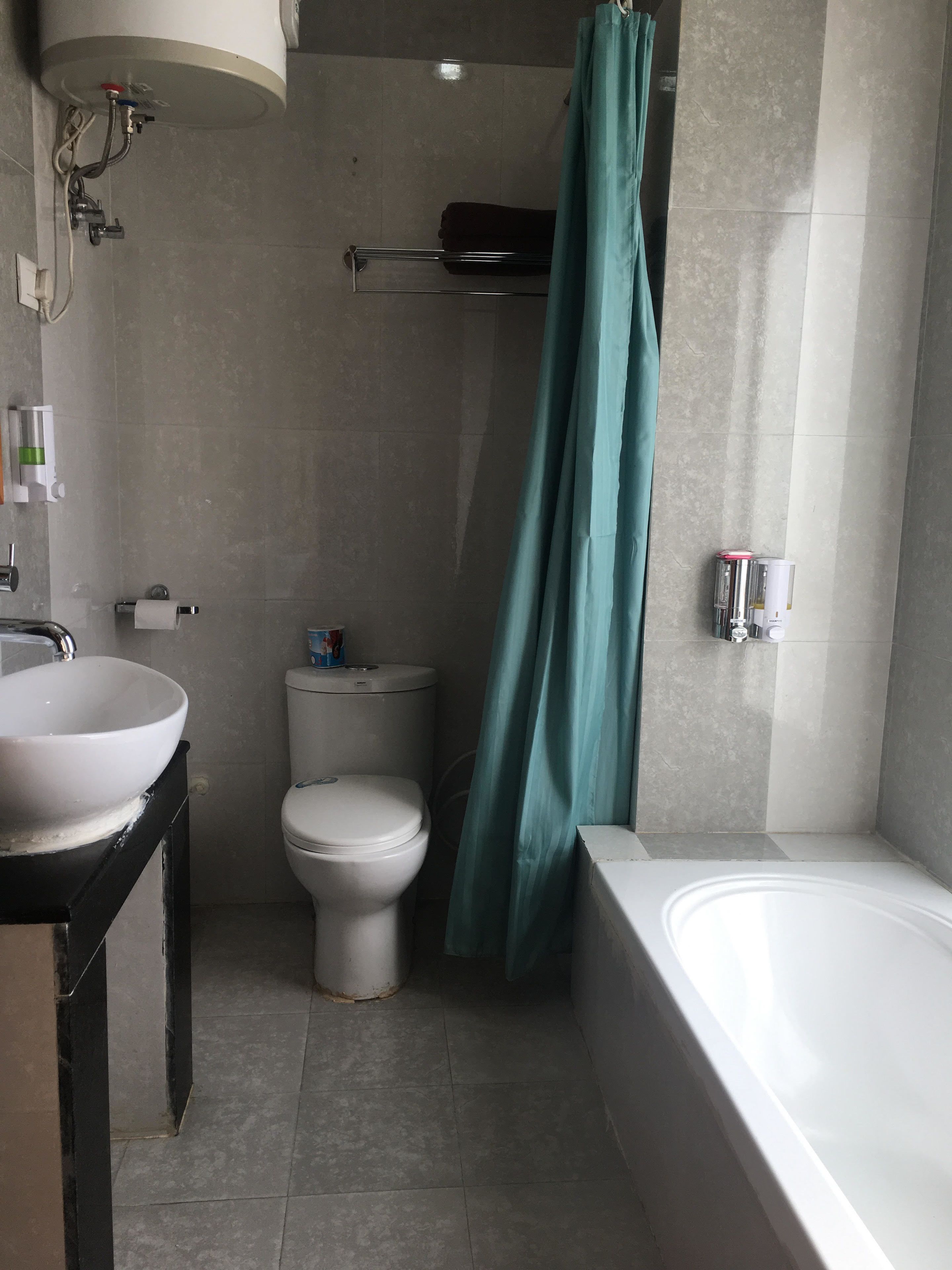 A bathroom with a sink, toilet, bathtub, and shower curtain.
