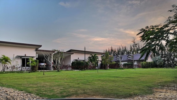 A residential area with houses, a grassy lawn, and trees.