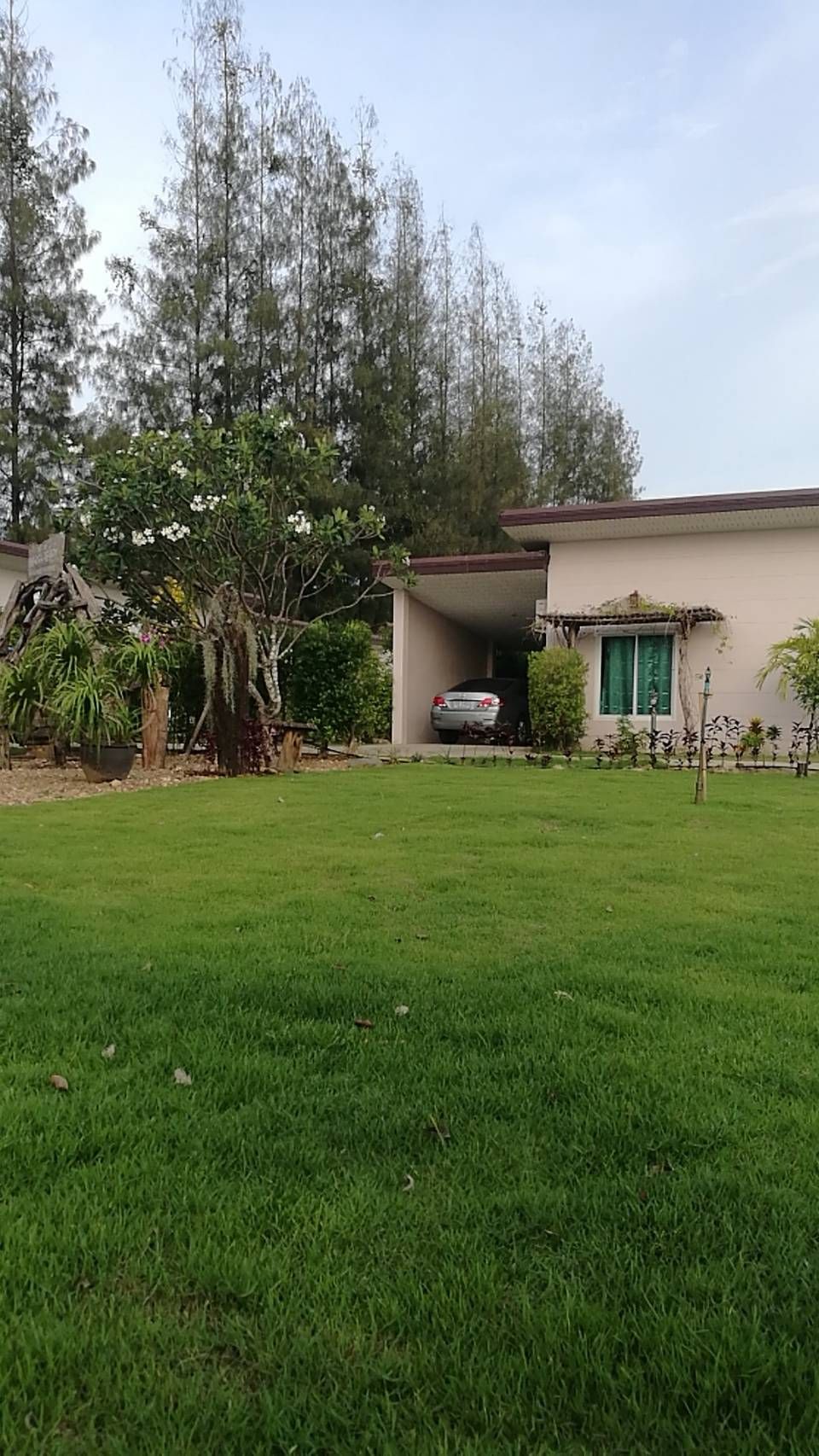Il s’agit d’une propriété résidentielle dotée d’une pelouse bien entretenue, d’un garage et d’une maison avec un toit en tuiles.