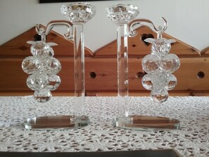 Two crystal candle holders on a textured white table.