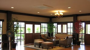 A spacious lobby with large windows, wicker furniture, and a chandelier. - Northstar Hotel and Resort (Chiang Rai)