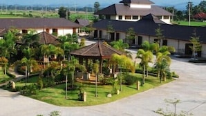 A resort with multiple buildings, a central gazebo, and palm trees. - Northstar Hotel and Resort (Chiang Rai)