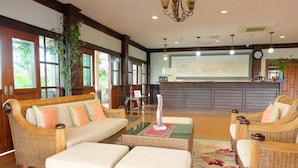 A spacious lobby with wicker furniture, a reception desk, and large windows. - Northstar Hotel and Resort (Chiang Rai)