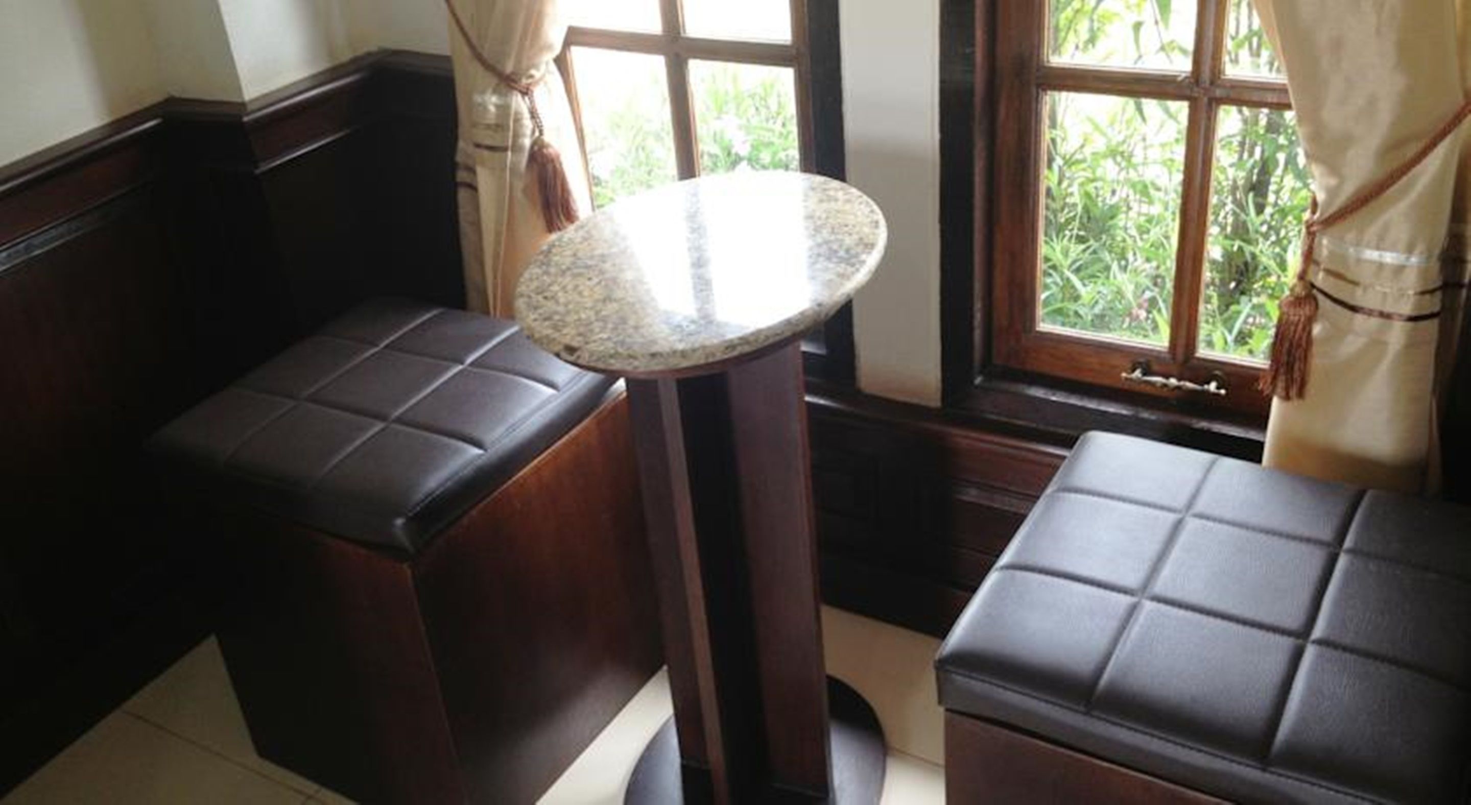 A corner seating area with a round table and two cushioned benches.