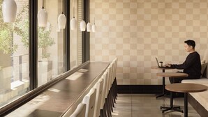 A modern interior with a long table, chairs, and a sofa. - Nesthotel alt. Meguro Station (Tokyo)