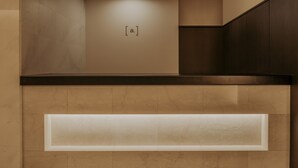 A modern interior with a recessed shelf and a wall-mounted light fixture. - Nesthotel alt. Meguro Station (Tokyo)