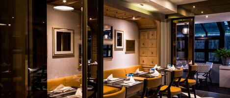 Un restaurante con una decoración moderna, que combina elementos de madera y vidrio, y un suelo con diseño.