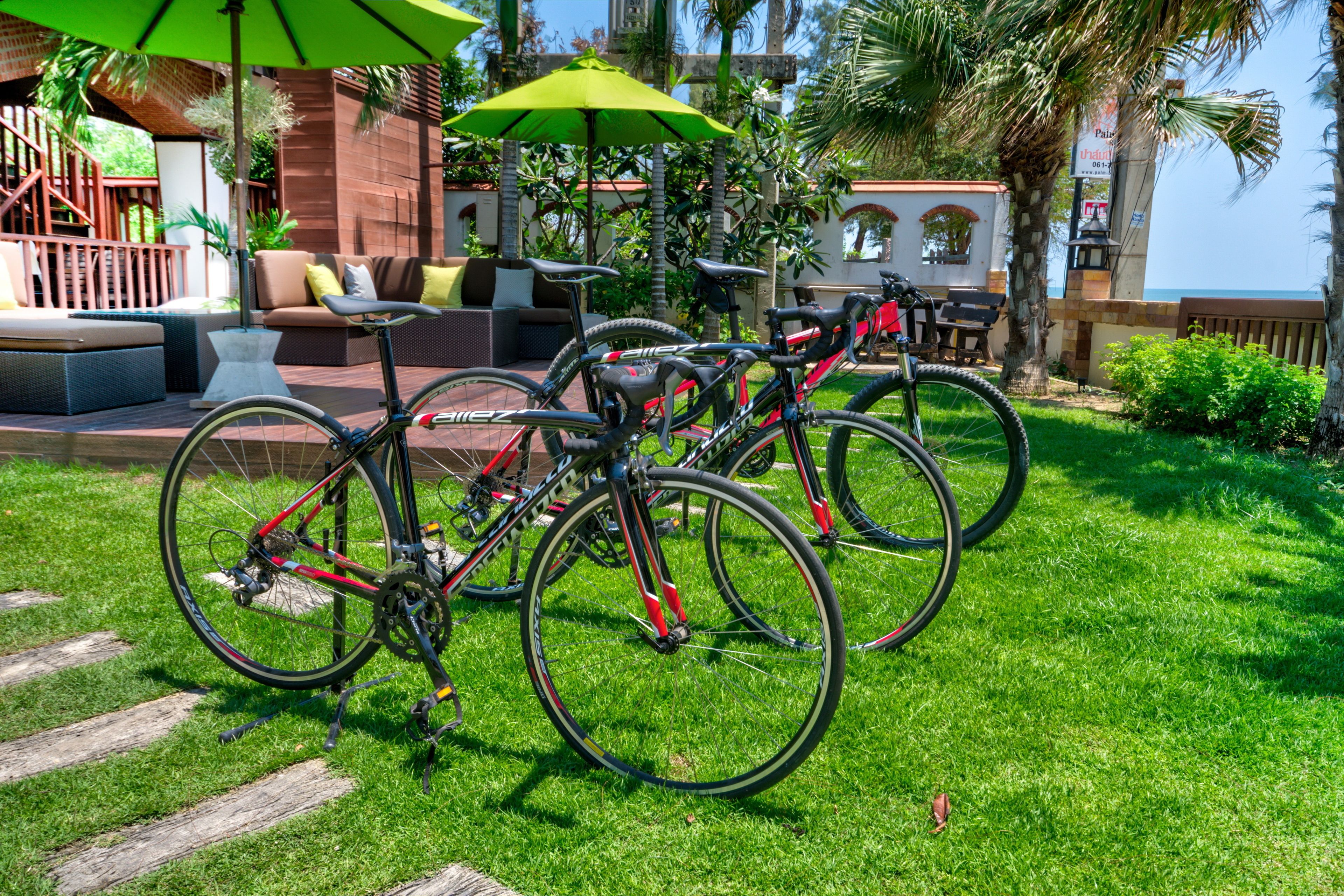 A patio area with outdoor seating, bicycles, and umbrellas.