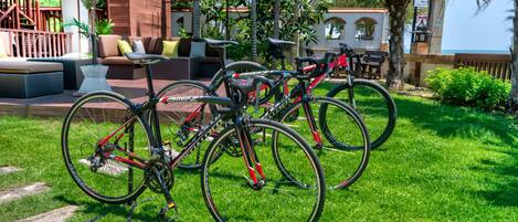 A patio area with outdoor seating, bicycles, and umbrellas.