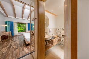 A modern bedroom with a wooden ceiling, a large bed, a desk, and a view of greenery. - Purple Palms Resort & Spa Coorg, a member of Radisson Individuals Premier (Somvarpet)