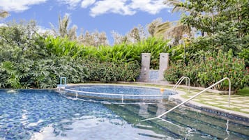 Una piscina al aire libre, sillones reclinables de piscina