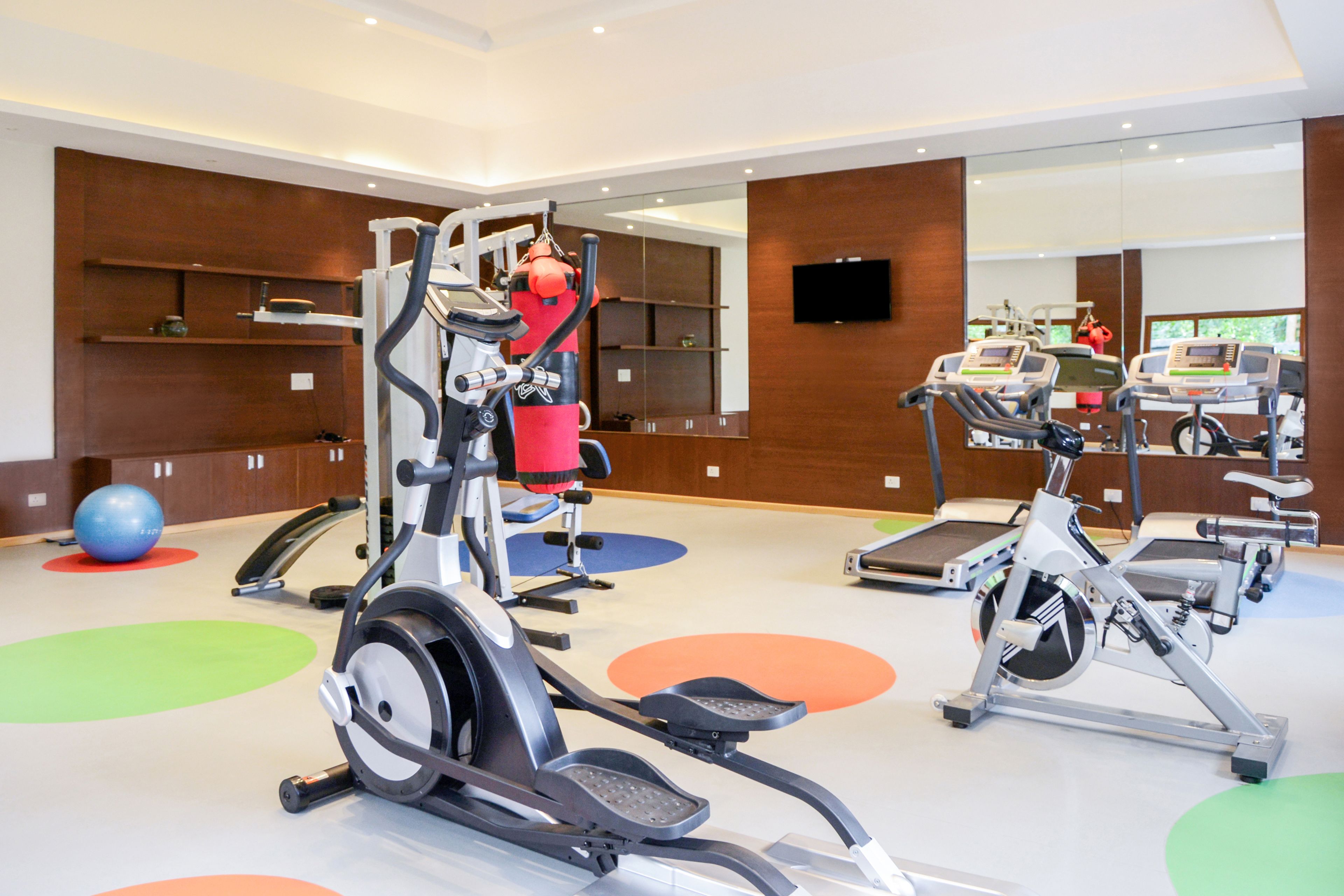Une salle de sport équipée de vélos d’appartement, de machines elliptiques et d’un rameur.
