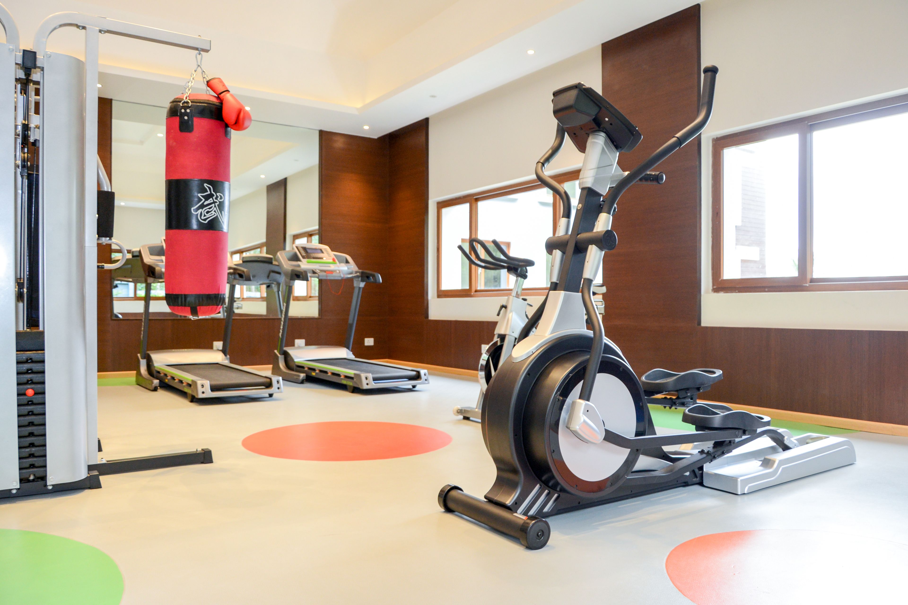 A gym with treadmills, an elliptical, and a punching bag.