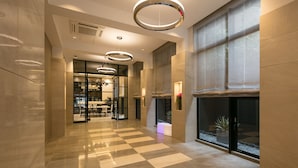 A modern hotel lobby with checkered flooring, circular ceiling lights, and large windows. - Hotel M’s Plus Shijo - Omiya (Kyoto)