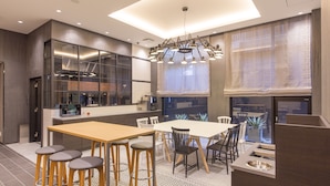 A modern kitchen with a central island, bar stools, and a dining area with chairs. - Hotel M’s Plus Shijo - Omiya (Kyoto)