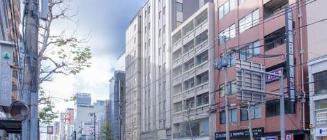 Un hotel de varios pisos con una fachada moderna, varios balcones y una prominente 'M' en el edificio.