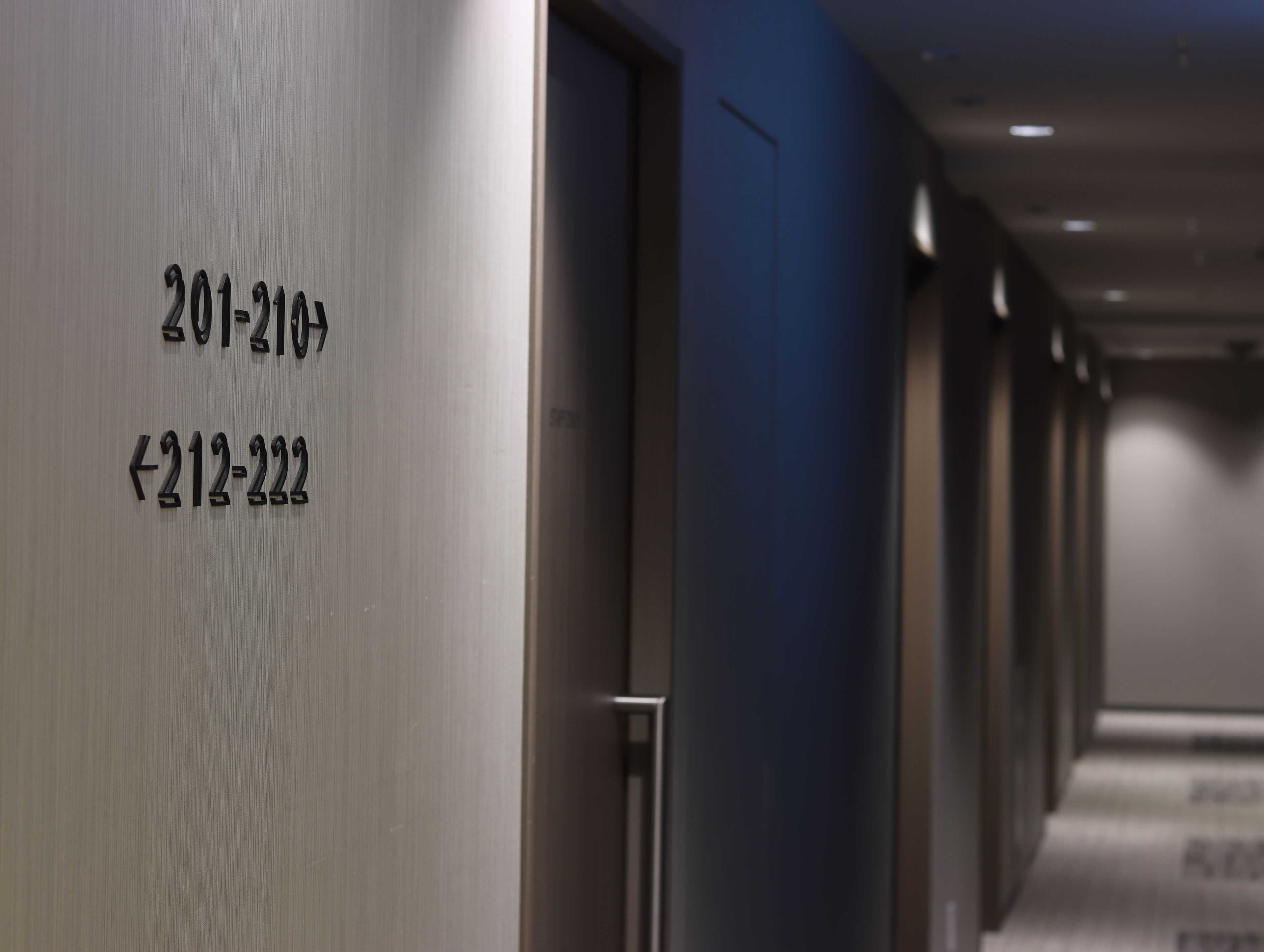 A hallway with doors labeled 201-210 and 212-222.