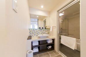 A modern bathroom with a glass-enclosed shower, a white sink, and a tiled backsplash. - Hotel M’s Plus Shijo - Omiya (Kyoto)