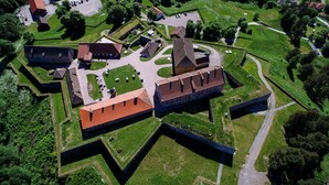 An aerial view of a historic fort with a central courtyard, surrounding walls, and several buildings with red-tiled roofs. - Kongsvinger Castle Hotel & Resort (Kongsvinger)