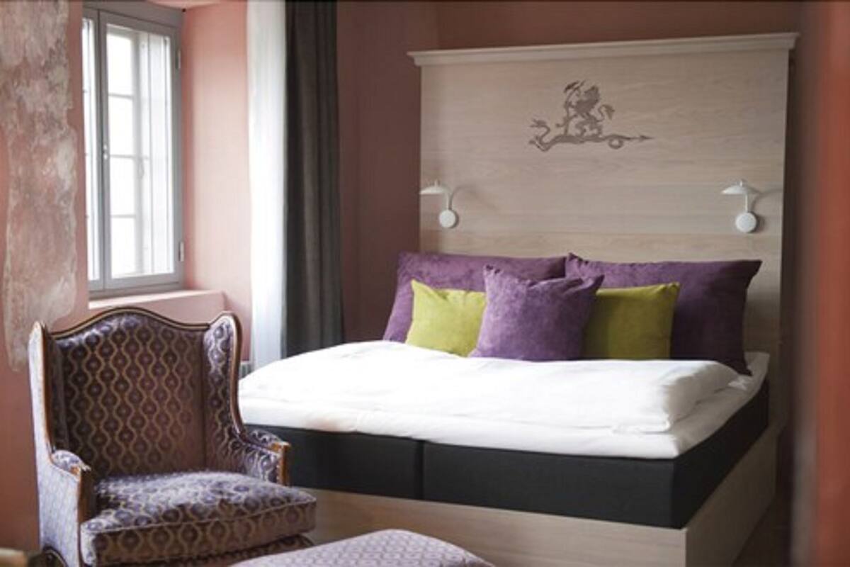 Une chambre à coucher avec un lit, une chaise et une table de chevet.