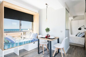 Loft panoramico, 1 letto queen, vista mare, di fronte alla spiaggia | Soggiorno | TV a schermo piatto 22 pollici con canali satellitari, TV