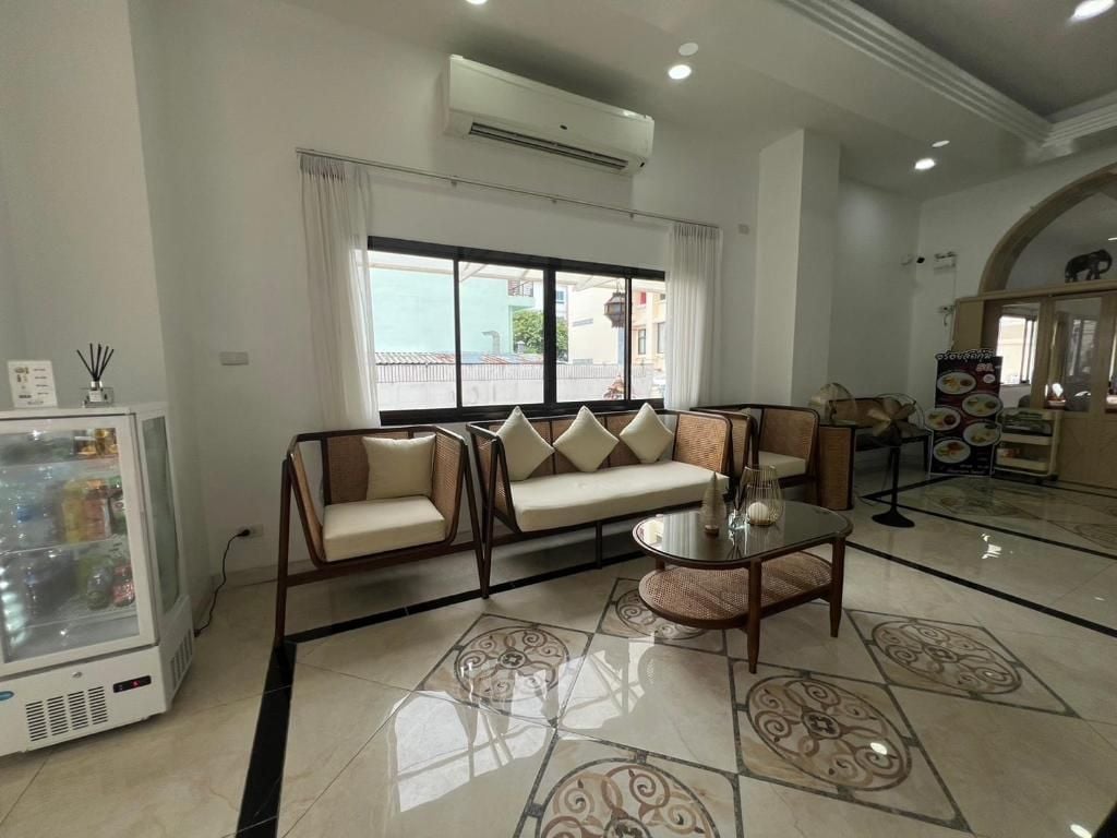A modern living area with a sofa set, a glass coffee table, and a decorative rug.