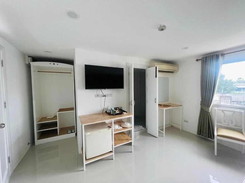 A modern hotel room with a flat-screen TV, built-in wardrobe, and a balcony with a view.