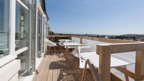 A wooden deck with white tables and chairs, overlooking a cityscape. - The Mount Rooms (Barry)