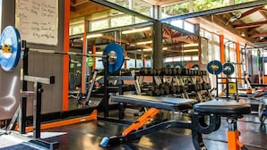 A gym with weightlifting equipment, benches, and a whiteboard with exercise information. - The Mount Rooms (Barry)