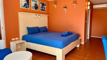 Un dormitorio con cama, mesita de noche, una silla y estante de pared con objetos decorativos.