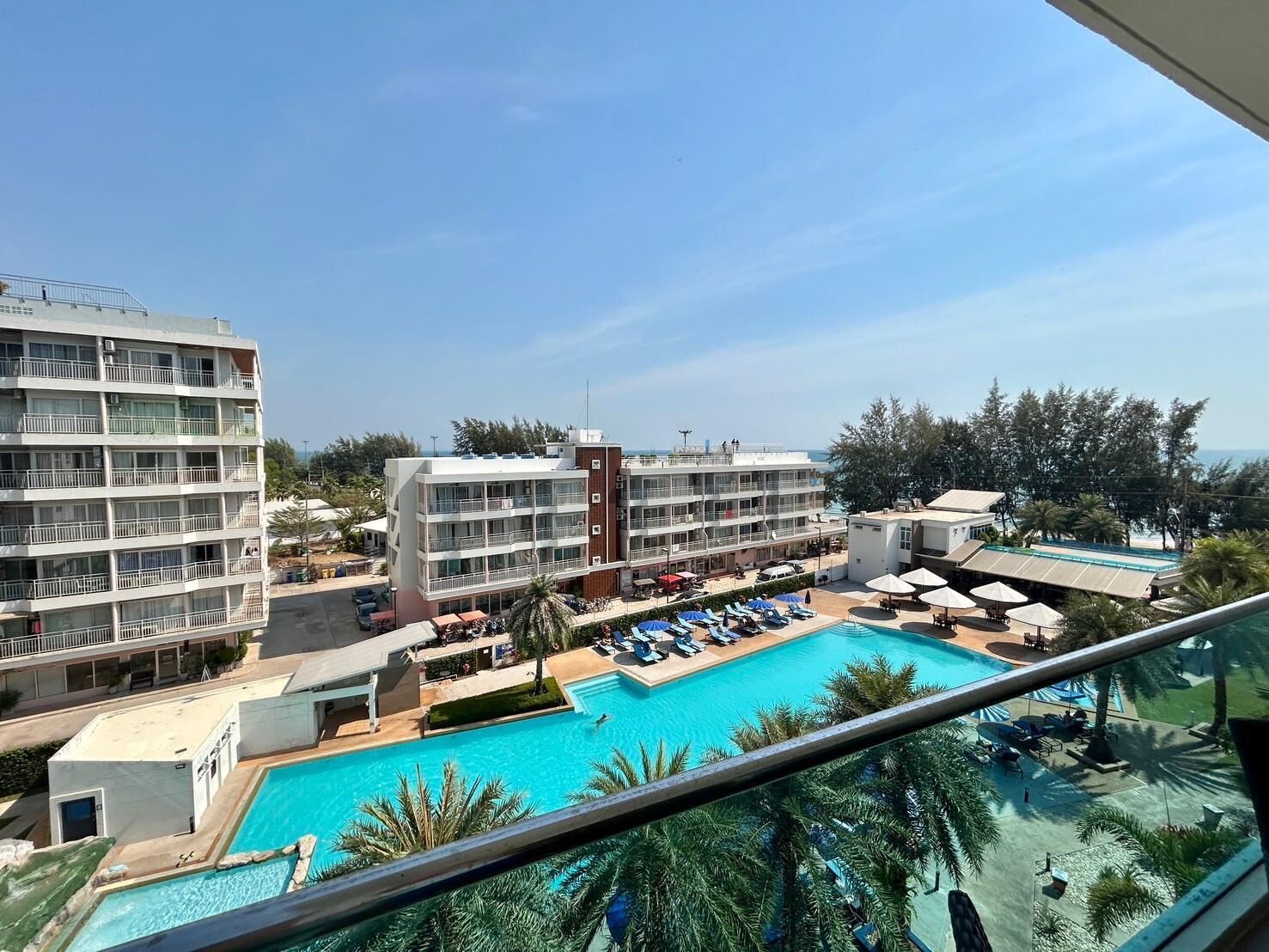A hotel with multiple floors, a swimming pool, and a view of the ocean.